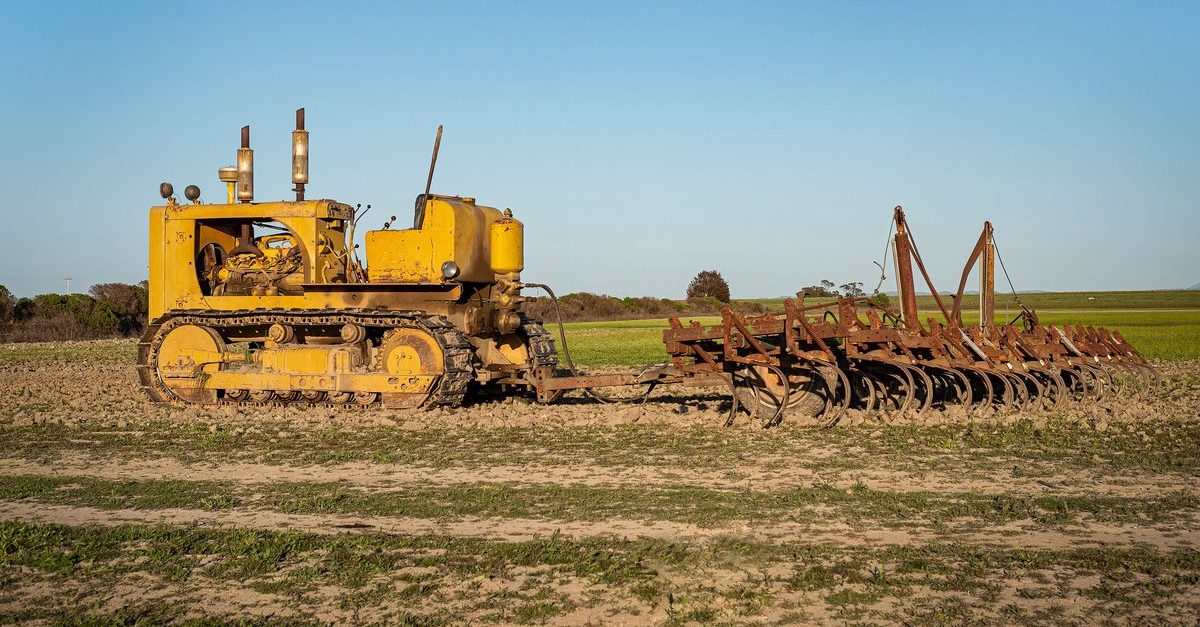 Heavy machinery clearing brush in a Texas pasture field with remaining trees and fence lines